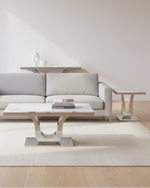 Three-piece white marble and stainless steel coffee table set with curved chrome base
