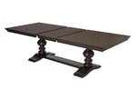 A dark brown wooden extendable dining table with leaf and pedestal base.