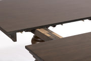 Close-up of a dark wood extendable dining table showing the table top, support frame, and pull-out mechanism