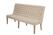 A tufted upholstered dining bench with a beige-colored fabric and rustic wood legs